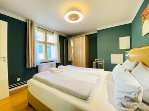 a bedroom with two white beds and a green wall at Amaroo - Serviced Apartments "Branden" in Potsdam +9 photos
