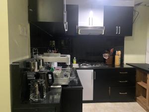 a kitchen with black cabinets and a white stove top oven at Cozy Palm Villa in Jimbaran