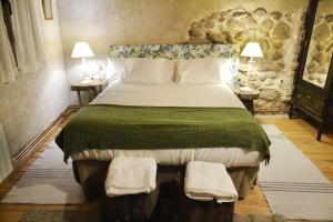 a bedroom with a large bed with two tables and two lamps at Casa Valle del Lozoya in Rascafría