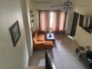 a living room with a couch and a table at Cozy Palm Villa in Jimbaran