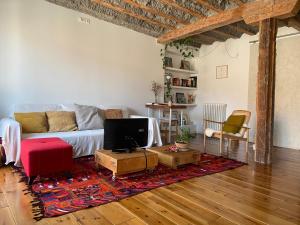 a living room with a couch and a tv at La linterna de San Lorenzo in Burgos