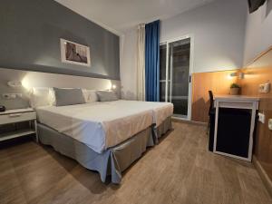 a hotel room with a large bed and a window at Rambla Alicante Contactless in Alicante