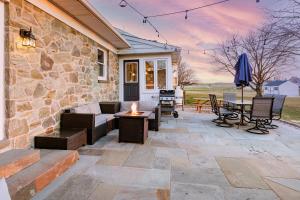 un patio con mesa, sillas y pared de piedra. en The Craftsman's Homestay en Gordonville