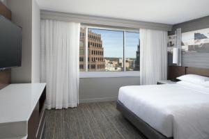カンザスシティにあるカンザス シティ マリオット カントリー クラブ プラザのベッドと大きな窓が備わるホテルルームです。