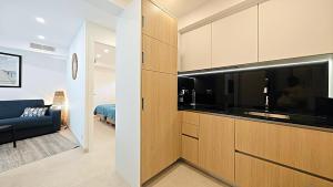 eine Küche mit Holzschränken und einem blauen Sofa in einem Zimmer in der Unterkunft Viva Riviera Brand New Top Floor close Croisette in Cannes