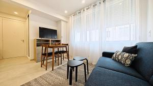 ein Wohnzimmer mit einem blauen Sofa und einem Tisch in der Unterkunft Viva Riviera Brand New Top Floor close Croisette in Cannes