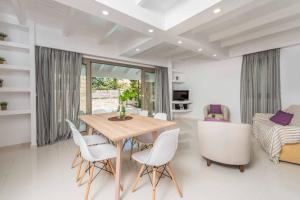 a dining room with a table and white chairs at Villa Lefki Sofita in Makris Gialos