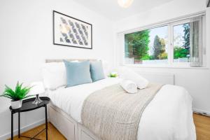 a white bedroom with a bed and a window at Luxury 4 Bedroom Bungalow - Parking - Sutton Coldfield 75C in Birmingham