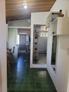 a room with a green tile floor and a kitchen at Studio 1 casazul in Salvador