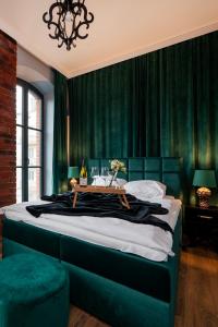 a bedroom with a large bed with green curtains at Restored Factory Residence - 55m2, Top Location - by Rentujemy in Łódź