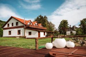 ein Haus mit einer Holzterrasse mit einer weißen Vase in der Unterkunft Casa cu Prispa in Sighişoara