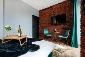 a bedroom with a brick wall and a bed with a table at Restored Factory Residence - 55m2, Top Location - by Rentujemy in Łódź