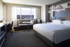 a hotel room with a large bed and a desk at Kansas City Marriott Country Club Plaza in Kansas City