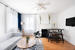 ein Wohnzimmer mit einem weißen Sofa und einem Tisch in der Unterkunft 11-4F Prime west village designer 1BR in New York
