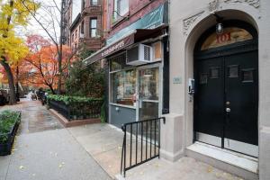 uma loja com uma porta preta numa rua da cidade em 11-4F Prime west village designer 1BR em Nova York