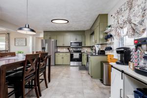 a kitchen with green cabinets and a table and chairs at The Craftsman's Homestay in Gordonville