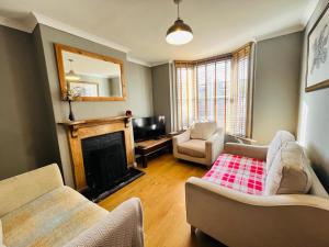 ein Wohnzimmer mit Couch und Kamin in der Unterkunft Edwards Cottage - Grove Road Cottages in Stratford-upon-Avon