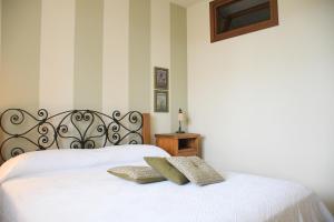 una camera con letto bianco e testiera di Simona's Home a Desenzano del Garda Altre 26 foto