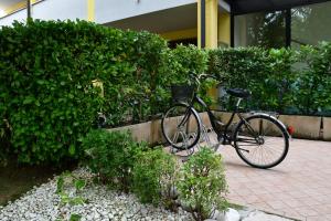 una bicicleta estacionada en una acera junto a un seto en Simona's Home en Desenzano del Garda