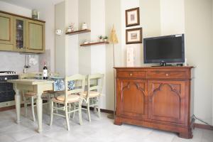 cocina con TV y mesa con sillas en Simona's Home en Desenzano del Garda