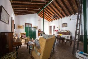 uma sala de estar com um sofá, cadeiras e uma mesa em La Casa del Cura 1935 em Alcalá de Guadaira