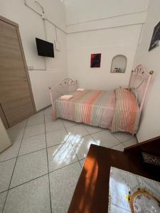 um quarto com uma cama e uma televisão na parede em Maria house em Scafati