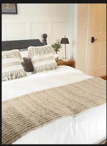 a bedroom with a large white bed with pillows at Auberge Glengarry Inn, The Mystic 