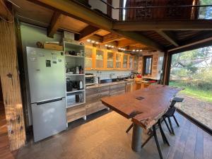 uma cozinha com uma mesa de madeira e um frigorífico em Cabaña en el bosque em Curicó