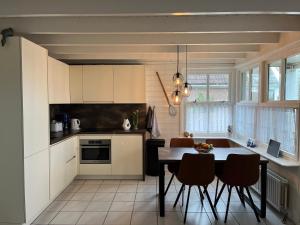 a kitchen with a table and chairs in a kitchen at Zijperbries in Oudesluis