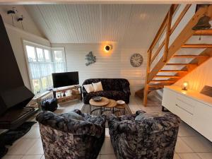a living room with two chairs and a staircase at Zijperbries in Oudesluis