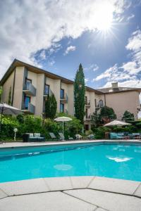a hotel with a swimming pool in front of a building at Best Western Bridge Hotel Lyon East in Jons