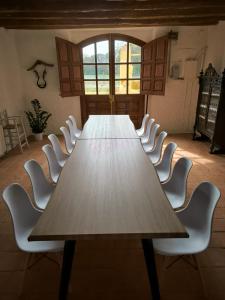 カルデス・デ・マラベーリャにあるMas Gelabertóの客室内の長いテーブルと白い椅子