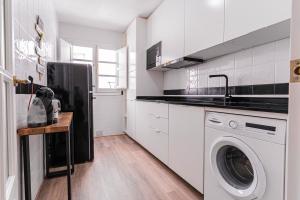 a white kitchen with a washer and dryer in it at Casa Arai en Casco Histórico con Parking Gratuito in Ronda