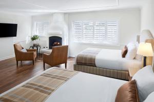 - une chambre d'hôtel avec 2 lits et une cheminée dans l'établissement Coachman's Inn, A Four Sisters Inn, à Carmel