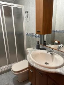 a bathroom with a toilet and a sink and a shower at Tu casita en El Zapillo in Almería