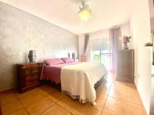 sypialnia z łóżkiem, komodą i oknem w obiekcie Casa Cony w mieście Tarifa
