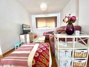 salon z kanapą i wazą kwiatów w obiekcie Casa Cony w mieście Tarifa