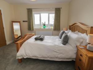 Un dormitorio con una gran cama blanca y una ventana en Tan Twr en Llanfairpwllgwyngyll