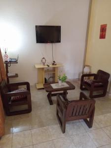 sala de estar con muebles de madera y TV de pantalla plana en Apart incone en Formosa