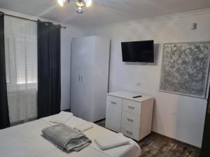 ein Schlafzimmer mit einem Bett und einem TV an der Wand in der Unterkunft CasaRiana 1 in Eforie Sud