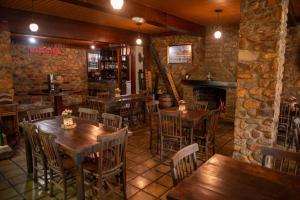 um restaurante com mesas e cadeiras de madeira e uma lareira em Pousada Baixa Verde em Triunfo
