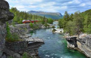 a train traveling over a river with a bridge at Heinåli apartment in Isfjorden