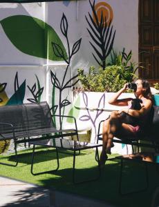 a woman sitting on a chair drinking a glass of wine at El Sofá Caracas in Caracas