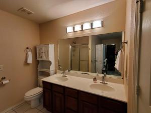 een badkamer met een wastafel, een toilet en een spiegel bij Master Bed & Bath Just For You in Bentonville