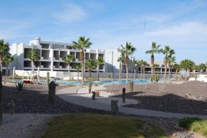 ein Resort mit Swimmingpool und Palmen in der Unterkunft Casa Adams Torre 13-202 Mayan Lakes Resort in Playa Encanto