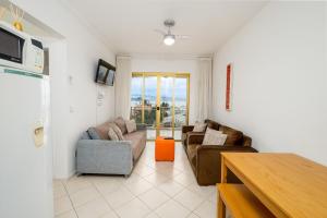 ein Wohnzimmer mit 2 Sofas und einem Tisch in der Unterkunft Apto c/ vista para o mar em Canasvieiras IDO201 in Florianópolis