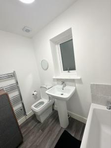 bagno bianco con servizi igienici e lavandino di Beautiful home a Ince-in-Makerfield