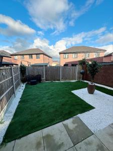 a small backyard with a fence and a grass yard at Beautiful home in Ince-in-Makerfield