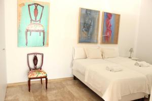 1 dormitorio con 2 camas y 1 silla en Nuevo Estudio moderno, agradable y cómodo, en Sevilla