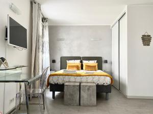 1 dormitorio con 1 cama con sábanas amarillas y almohadas amarillas en Elegant studio proche Palais des Festivals, en Cannes
